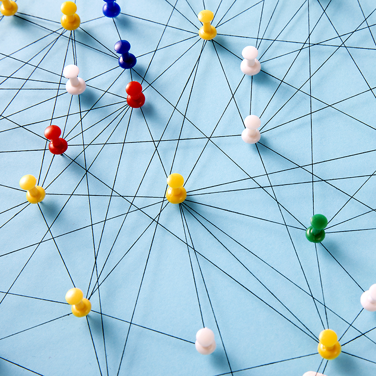 Colorful push pins connected by black lines on a blue background, forming a network pattern.